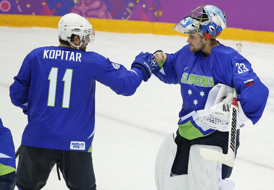 Slovenia forward Anze Kopitar bumps fists with goaltender Robert Kristan after Slovenia beat Austria 4-0 in a men's ice hockey game at the 2014 Winter Olympics, Tuesday, Feb. 18, 2014, in Sochi, Russia. Slovenia advanced to the quarterfinals. (AP Photo/Julio Cortez)