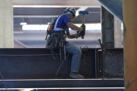 A worker pounds a wedge as he works on a beam, Tuesday, Sept. 1, 2020, at the Climate Pledge Arena in Seattle, the home of the Seattle Kraken NHL hockey team. Sometime in the late summer or early fall of 2021, the Kraken will open the new facility -- at a cost that will likely total $1 billion by the time it's done -- and become the NHL's 32nd franchise. (AP Photo/Ted S. Warren)