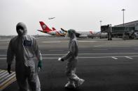 Customs officers in protective suits are seen near a Sichuan Airlines aircraft on the tarmac of Chengdu Shuangliu International Airport