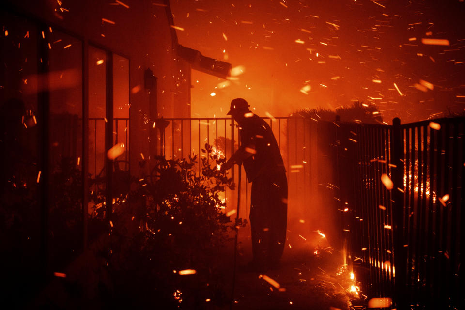 Jerry Rowe uses a garden hose to save his home on Beaufait Avenue from the Saddleridge fire in Granada Hills, Calif., Friday, Oct. 11, 2019.  (Photo: Michael Owen Baker/AP)