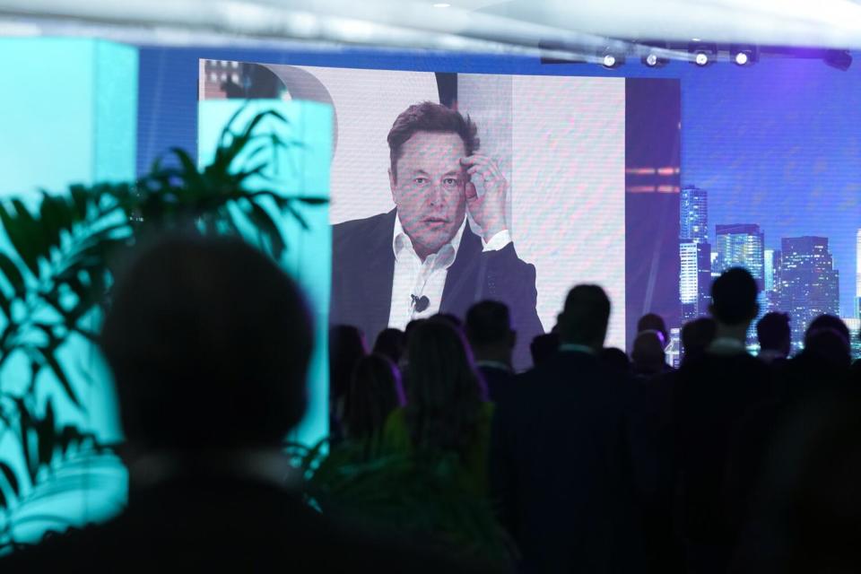 Elon Musk is broadcast on a screen.