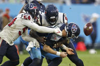 Tennessee Titans quarterback Ryan Tannehill (17) fumbles the ball as he is hit by Houston Texans defensive end Jacob Martin (54) in the second half of an NFL football game Sunday, Nov. 21, 2021, in Nashville, Tenn. (AP Photo/Wade Payne)