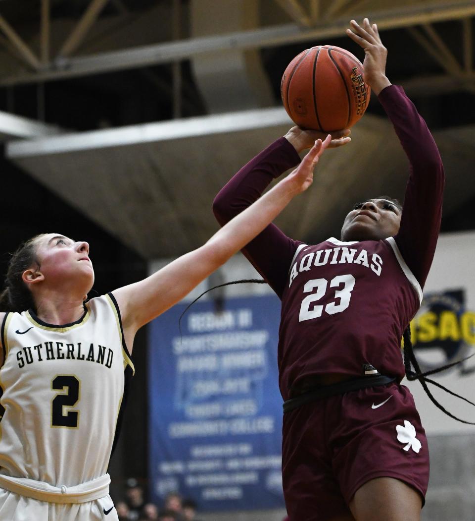 Jade Harvey of Aquinas gets fouled by Pittsford Sutherland's Lucy Bush.