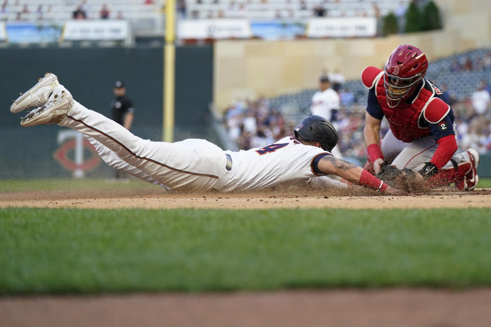 Minnesota Twins' Jose Miranda beats the tag by Boston Red Sox catcher Reese McGuire to score during the first inning of a baseball game Tuesday, Aug. 30, 2022, in Minneapolis. (AP Photo/Abbie Parr)