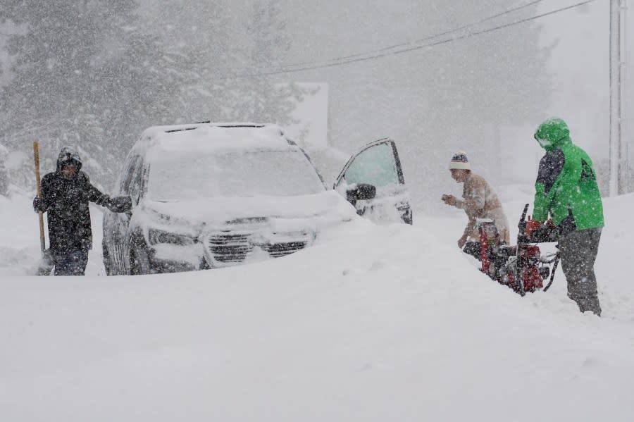 Residents try to clear snow during a storm, Saturday, March 2, 2024, in Truckee, Calif. (AP Photo/Brooke Hess-Homeier)