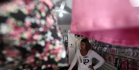 Valeria Rocha talks to Reuters in her baby clothes store at Jardim Sao Luis, near the edge of Sao Paulo August 28, 2014. REUTERS/Paulo Whitaker