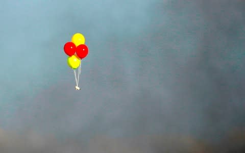 A stack of balloons loaded with incendiaries is flown towards Israel from Gaza  - Credit: MAHMUD HAMS/AFP/Getty Images