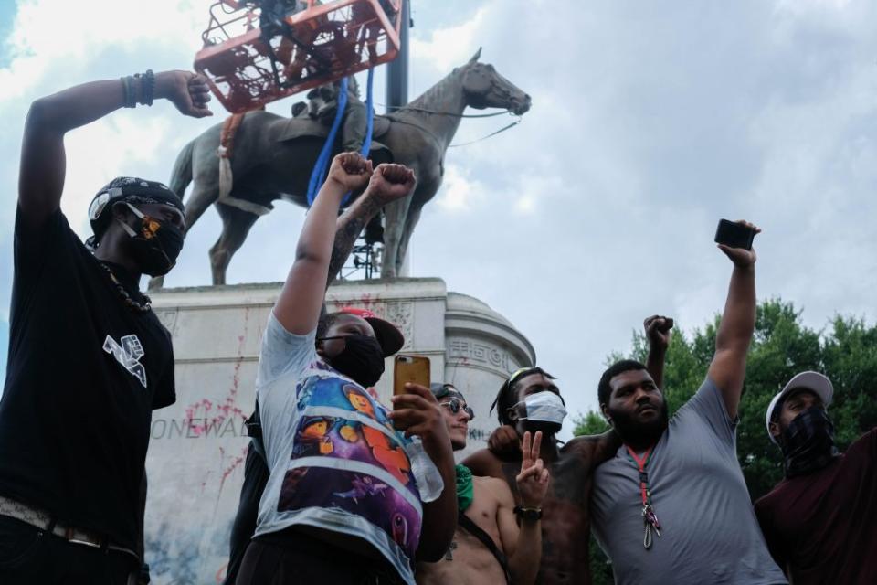  A crowd grew as workers spent about four hours rigging and preparing a statue of Confederate Gen. Stonewall Jackson for removal from Monument Avenue in Richmond in 2020. (Ned Oliver/Virginia Mercury)