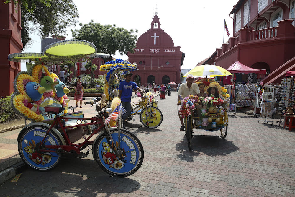 Tourists take a photo in front of the Stadthuys Building in Melaka April 1, 2018. — Picture by Yusof Mat Isa