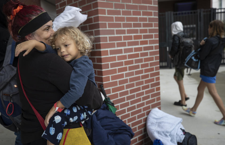 Celia Salazar holds her grandson Ricardo Salazar Jr. as they check into the emergency shelter at Largo High School as the Tampa Bay region prepares for the high winds and water from Hurricane Ian in Largo, Fla., Wednesday, Sept. 28, 2022. (Willie J. Allen Jr./Orlando Sentinel via AP)