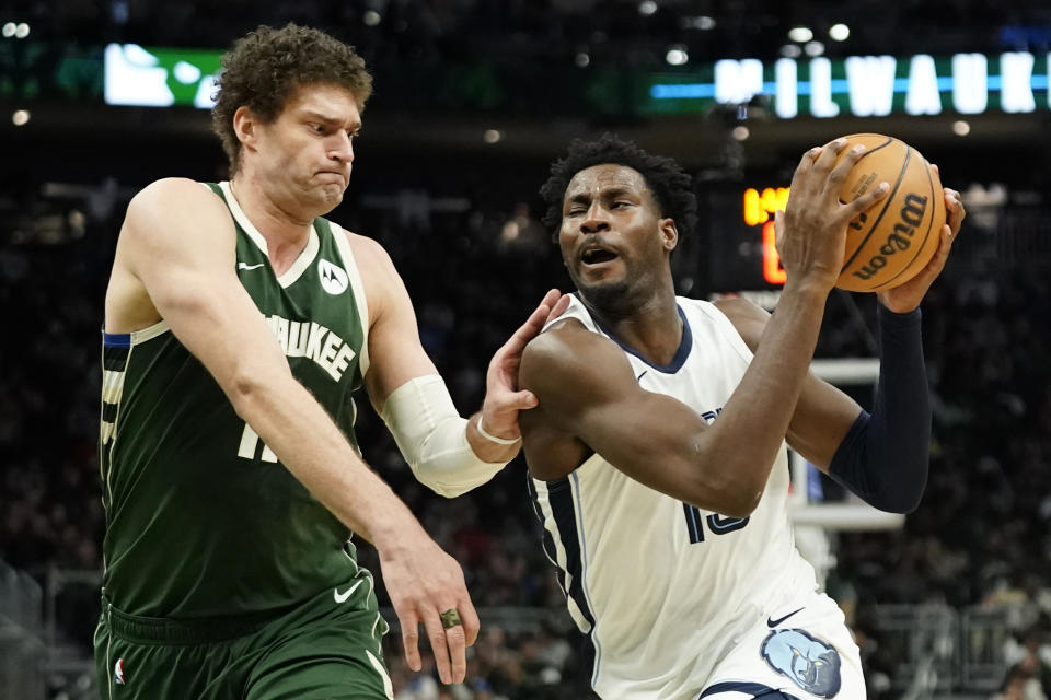 Memphis Grizzlies' Jaren Jackson Jr., right, drives to the basket against Milwaukee Bucks' Brook Lopez during the second half of an NBA basketball game Wednesday, April 3, 2024, in Milwaukee. (AP Photo/Aaron Gash)