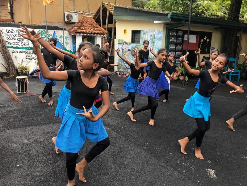 Children learn traditional dancing at a tsunami-hit village, in Seenigama, Sri Lanka