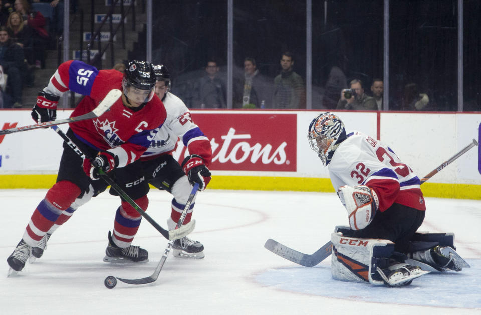 FILE - In this Thursday, Jan. 16, 2020, file photo, Team Red center Quinton Byfield (55) moves in on Team White goaltender Dylan Garand (32) while defended by Jack Thompson (23) during the second period of hockey's CHL Top Prospects Game in Hamilton, Ontario. Byfield is one of the top NHL draft prospects. (Peter Power/The Canadian Press via AP, File)