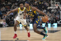 Indiana Pacers guard Buddy Hield (24) drives to the basket as Utah Jazz guard Collin Sexton (2) defends during the first half of an NBA basketball game Friday, Dec. 2, 2022, in Salt Lake City. (AP Photo/Rick Bowmer)
