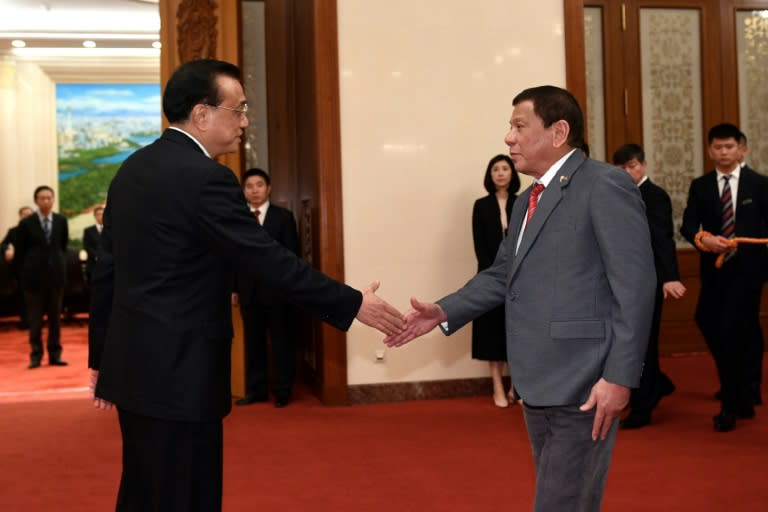 Chinese Premier Li Keqiang (L) shakes hands with Philippine President Rodrigo Duterte before a meeting at the Great Hall of the People in Beijing