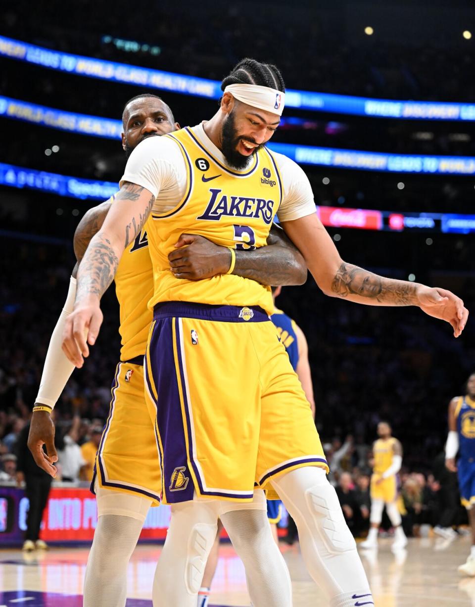Lakers star LeBron James hugs Anthony Davis in the fourth quarter against the Warriors on Friday.