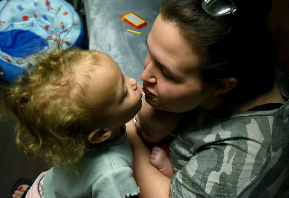 In their room at Oaks Shelter for the homeless in Monroe, Violet Daykin, 3, gives her mom, Romy Kelley, a big kiss before getting changed for the day.