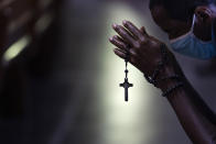 Con un rosario alrededor de su mano, un hombre se inclina en oración durante una misa en la Catedral Metropolitana de Río de Janeiro, Brasil, el sábado 4 de julio de 2020. Después de atenuarse las restricciones relacionadas con el COVID-19, la iglesia católica de Río celebró su primera misa con el 30% de sus fieles, que cumplieron medidas preventivas para frenar la propagación del nuevo coronavirus. (AP Foto/Leo Correa)