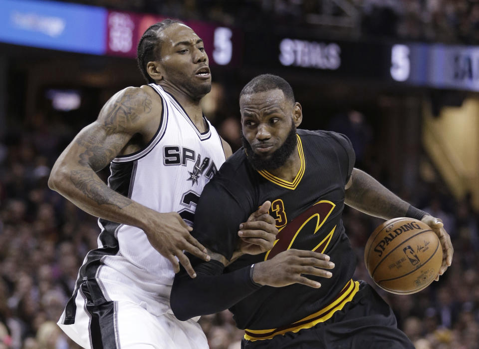 Cleveland Cavaliers' LeBron James, right, drives against San Antonio Spurs' Kawhi Leonard during the second half of an NBA basketball game, Saturday, Jan. 21, 2017, in Cleveland. The Spurs won 118-115 in overtime. (AP Photo/Tony Dejak)