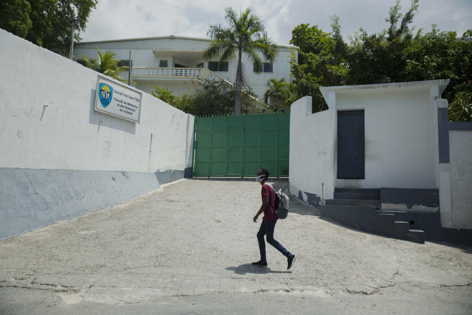 A pedestrian walks past the Catholic University of Notre Dame of Haiti in the Croix-des-Bouquets neighborhood of Port-au-Prince, Haiti, Wednesday, April 21, 2021. Catholic institutions including schools and universities closed Wednesday across Haiti as part of a three-day protest to demand the release of nine people including five priests and two nuns kidnapped more than a week ago amid a spike in violence the government is struggling to control. (AP Photo Joseph Odelyn)