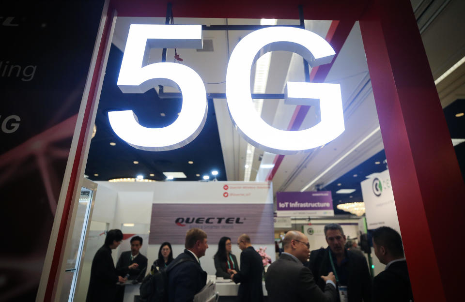 Attendees and workers chat beneath a 5G logo at the Quectel booth at CES 2020 at the Las Vegas Convention Center on January 8, 2020 in Las Vegas, Nevada. / Credit: Mario Tama  / Getty Images