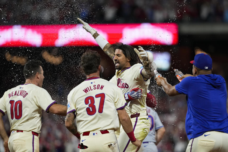 Philadelphia Phillies' Nick Castellanos celebrates with teammates his one-run single against New York Mets pitcher Tylor Megill during the ninth inning to win Game 2 of a baseball NL Division Series, Sunday, Oct. 6, 2024, in Philadelphia. (AP Photo/Matt Slocum)