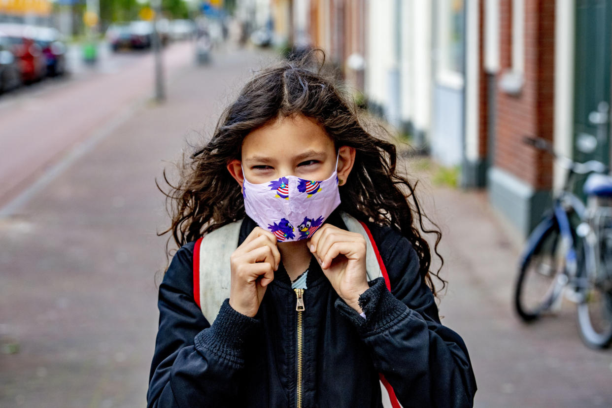 ROTTERDAM, NETHERLANDS - 2020/05/11: A kid going to school while wearing a face mask as a preventive measure against the spread of Coronavirus (COVID-19) crisis. Children go back to school in the Rotterdam district of Katendrecht, after the Coronavirus (COVID-19) lockdown crisis for half days. (Photo by Robin Utrecht/SOPA Images/LightRocket via Getty Images)
