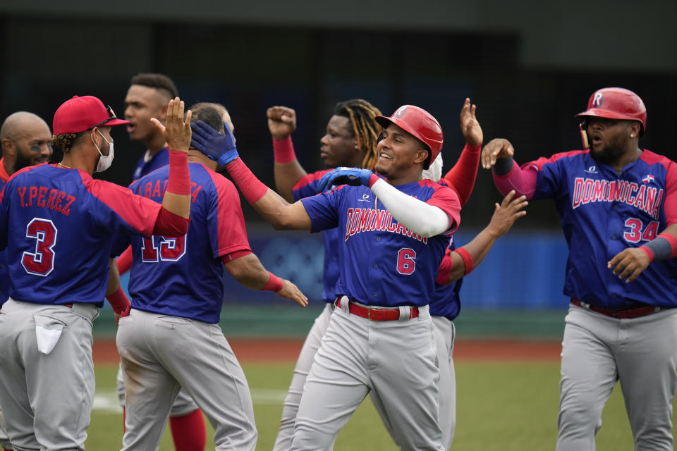 Dominican Republic's Erick Mejia(6) and Juan Francisco (34) celebrate after they scored on a double hit by Charlie Valerio during the seventh inning of a baseball game against Japan at the 2020 Summer Olympics, Wednesday, July 28, 2021, in Fukushima, Japan. (AP Photo/Jae C. Hong)