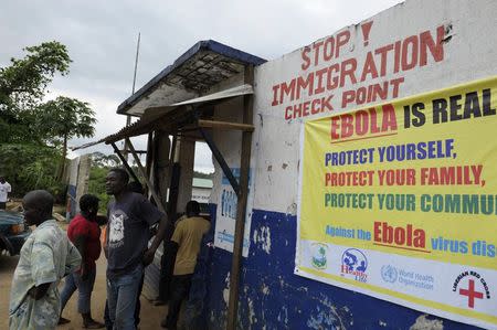 Liberian soldiers check people travelling in Bomi County August 11, 2014. REUTERS/Stringer