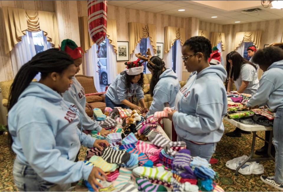 Poughkeepsie City School District students involved with the C.O.L.O.R.S. Foundation prepare holiday gifts for residents of The Pines at Poughkeepsie Center for Nursing and Rehabilitation, purchased with funding from Holiday Helping Hand, on Dec. 22, 2018.