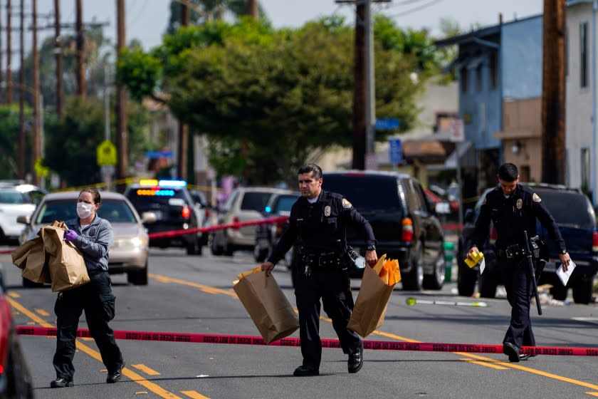 LONG BEACH, CA - JUNE 30: Law enforcement officers at scene of a shooting at the 5800 block of Orange Avenue on Tuesday, June 30, 2020 in Long Beach, CA. One woman was killed and two others injured Monday night when someone opened fire at a vigil held for a man who had been fatally shot a day earlier. (Kent Nishimura / Los Angeles Times)