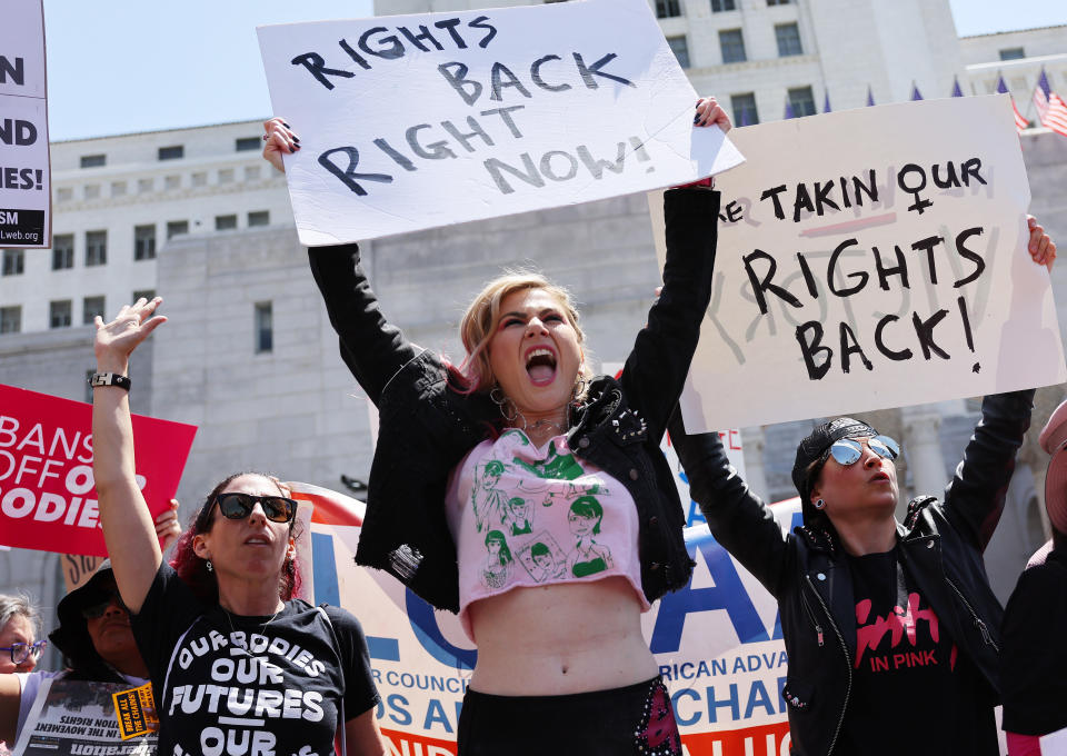 Protesters at the March for Reproductive Rights in Los Angeles hold signs that read: Rights back right now, Bans off our bodies, and We're takin' our rights back.