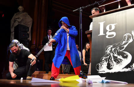 Didgeridoo instructor Alex Suarez, center, demonstrates the Ig Nobel Peace prize-winning study, "Didgeridoo Playing as Alternative Treatment for Obstructive Sleep Apnoea Syndrome," during the 27th First Annual Ig Nobel Prize Ceremony at Harvard University in Cambridge, Massachusetts, U.S. September 14, 2017. REUTERS/Gretchen Ertl