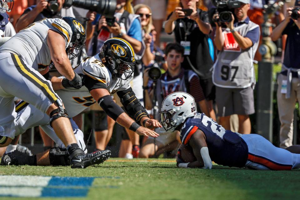 Auburn safety Cayden Bridges (20) recovers a fumble in the end zone to secure the win as Missouri offensive lineman Connor Tollison (55) reaches for the ball during overtime Saturday in Auburn, Ala.