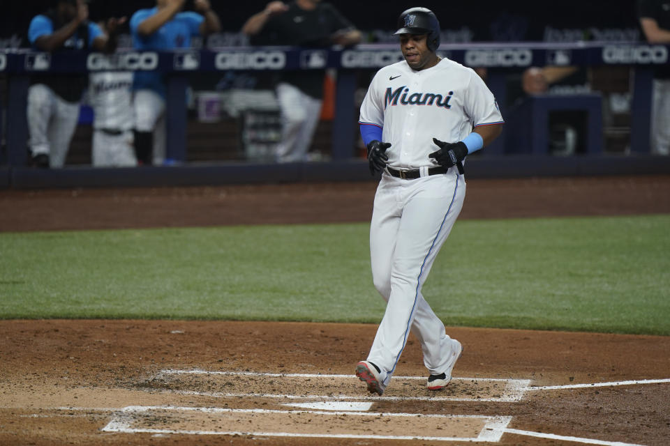 Miami Marlins' Jesus Aguilar scores on a single by Miguel Rojas during the second inning of a baseball game against the Colorado Rockies, Thursday, June 23, 2022, in Miami. (AP Photo/Wilfredo Lee)