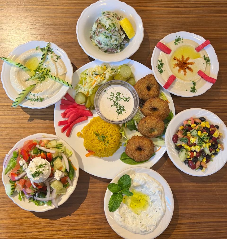 Mazah Mediterranean Eatery's falafel entree surrounded by six side options. The restaurant's falafels are both vegan and gluten-free, and made from scratch using a family recipe.