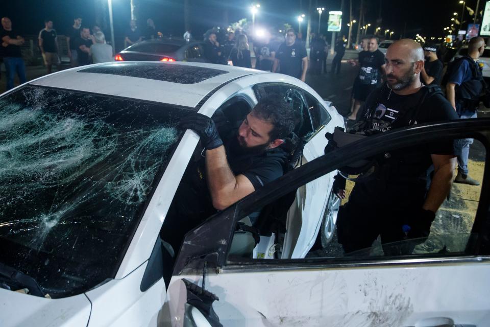 An Israeli police officer inspects the car of an Israeli Arab man who was attacked and seriously injured by a mob in Bat YamAmir Levy/Getty Images