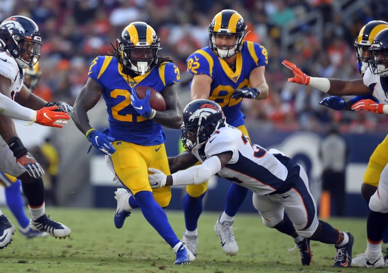 Los Angeles Rams running back Darrell Henderson, left, runs against the Denver Broncos during the first half of an NFL preseason football game Saturday, Aug. 24, 2019, in Los Angeles. (AP Photo/Mark J. Terrill)