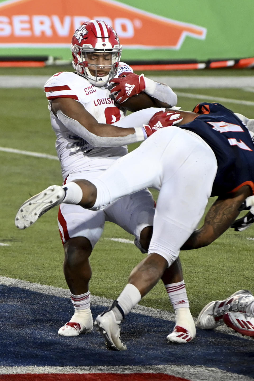 Louisiana-Lafayette running back Trey Ragas (9 scores the go-ahead touchdown as UTSA linebacker De'Marco Guidry (41) goes for the tackle during the fourth quarter of the First Responder Bowl NCAA college football game in Dallas, Saturday, Dec. 26, 2020. (AP Photo/Matt Strasen)