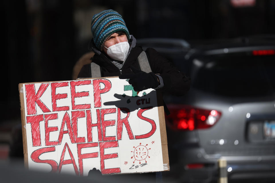 A Chicago Teachers Union supporter holding a poster that reads: Keep teachers safe