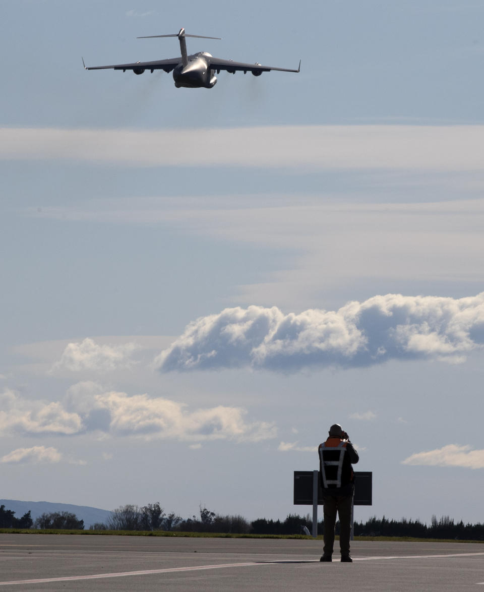 A photographer films a U.S. Air Force C-17 take off from Christchurch Airport in the season's first flight to McMurdo Station in Antarctica, Monday, Sept. 14, 2020. The first U.S. flight into Antarctica following months of winter darkness left from New Zealand Monday with crews extra vigilant about keeping out the coronavirus. (AP Photo/Mark Baker)