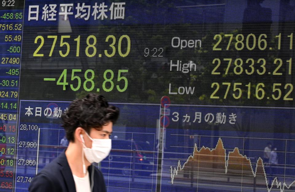 A man walks past an electronic quotation board displaying a share price of the Tokyo Stock Exchange in Tokyo on August 16, 2021. (Photo by Kazuhiro NOGI / AFP) (Photo by KAZUHIRO NOGI/AFP via Getty Images)