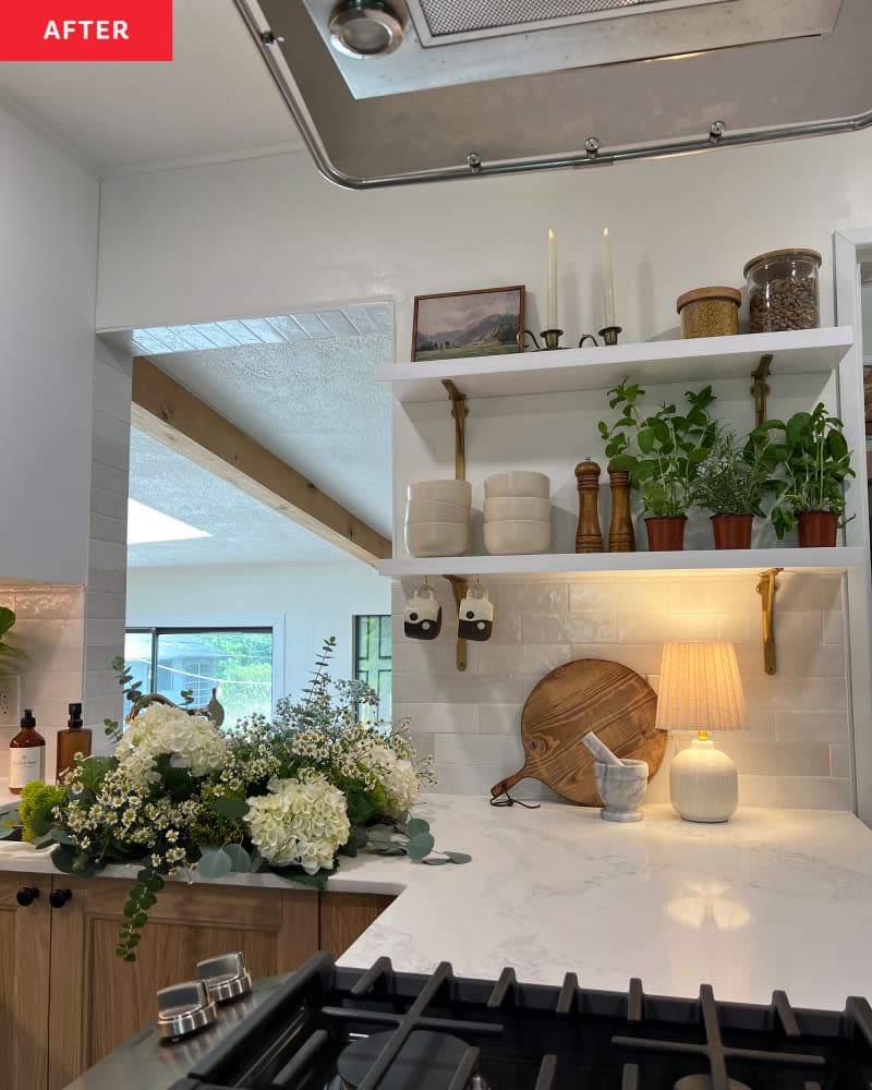 detail of white marble countertops, tile backsplash,  and white open shelves in white kitchen after remodel