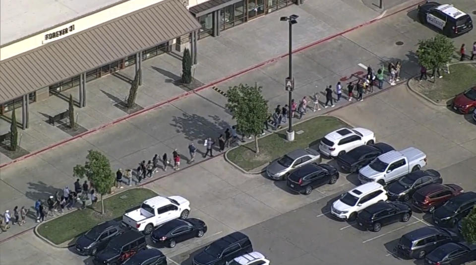 En esta imagen tomada de un video proporcionado por el canal de televisión WFAA, clientes y personal salen de un centro comercial en que se registró un tiroteo, el sábado 6 de mayo de 2023, en Allen, Texas. (WFAA vía AP)