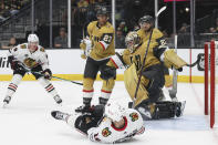 Chicago Blackhawks center Jason Dickinson (16) falls as Vegas Golden Knights goaltender Logan Thompson (36) makes a save during the first period of an NHL hockey game Tuesday, April 16, 2024, in Las Vegas. (AP Photo/Ian Maule)