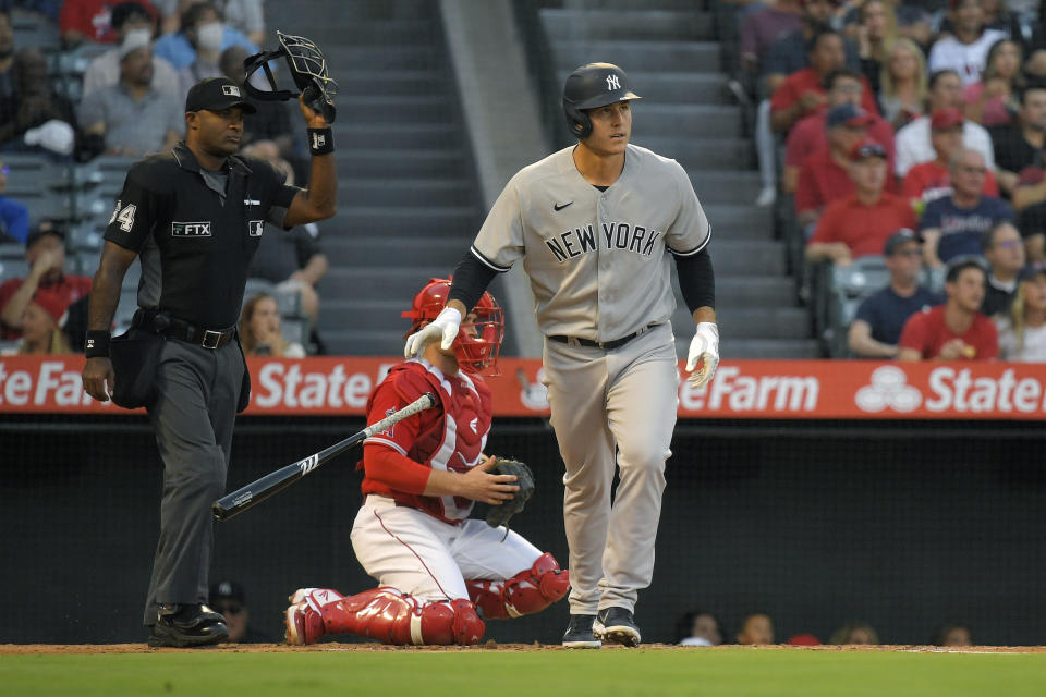 New York Yankees' Anthony Rizzo, right, drops his bat after hitting a solo home run while Los Angeles Angels catcher Max Stassi, center, and home plate umpire Alan Porter watch during the second inning of a baseball game Tuesday, Aug. 30, 2022, in Anaheim, Calif. (AP Photo/Mark J. Terrill)