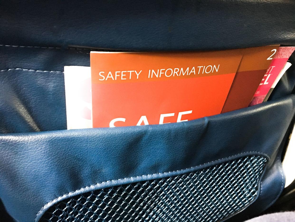 A safety information packet in the back of a plane seat pocket.