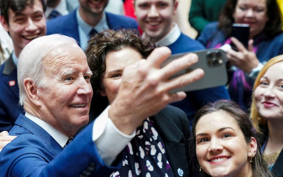 Joe Biden poses with students for selfies following his speech at Ulster University - Kevin Lamarque/Reuters 