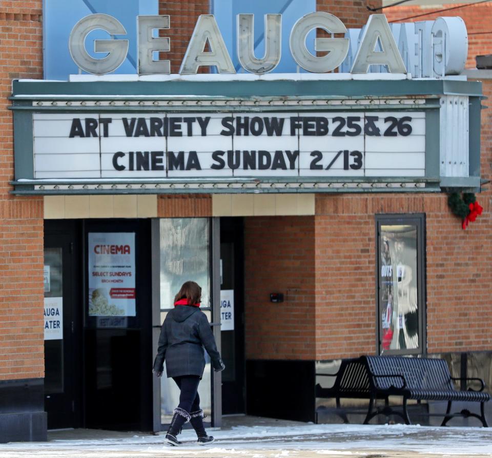 A woman walks under the marquee for the Geauga Theater Community Arts Center in Chardon.