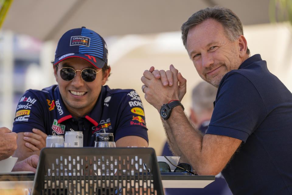 El jefe de Red Bull Christian Horner (derecha) charla con el piloto Sergio Pérez durante las pruebas de pretemporada en el circuito de Sakhir, Bahréin, el miércoles 21 de febrero de 2024. (AP Foto/Darko Bandic)